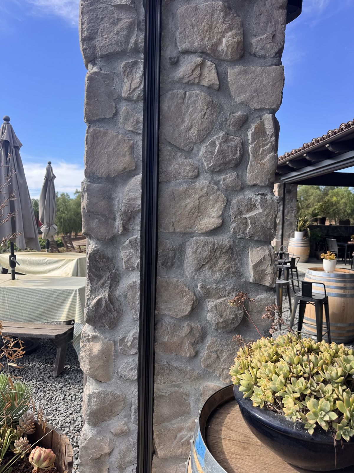 Close-up of a motorized screen track mounted on a stone column, craftsmanship detail