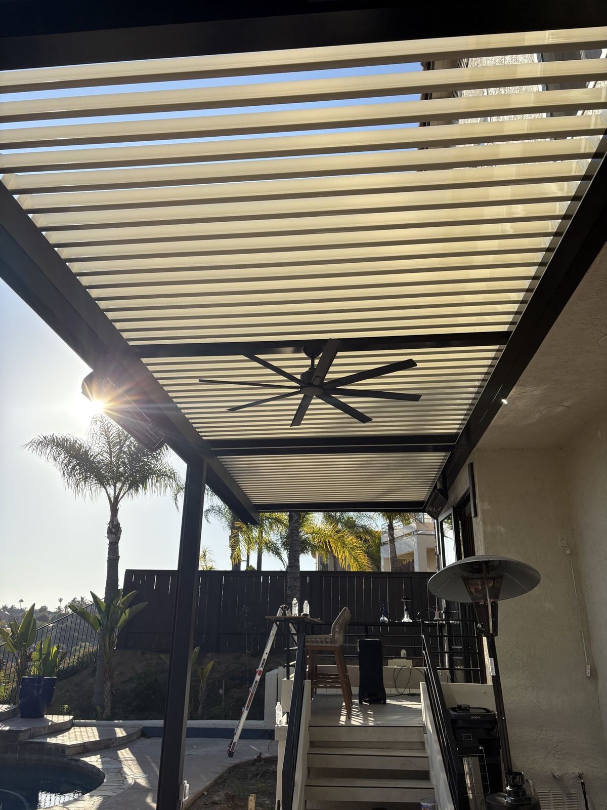 Louvered pergola with ceiling fan and heater, sun flare through the louvers
