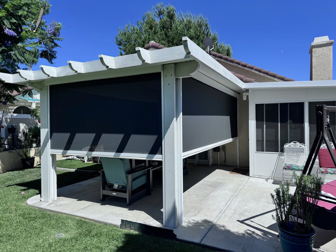 White pergola with deployed motorized screens, clean and crisp